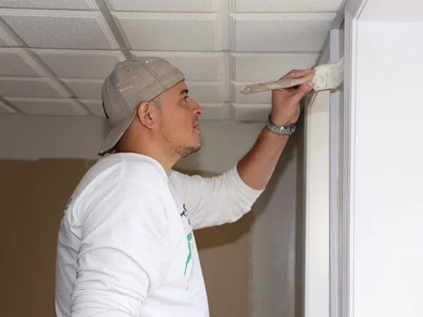 Man painting a wall with a brush