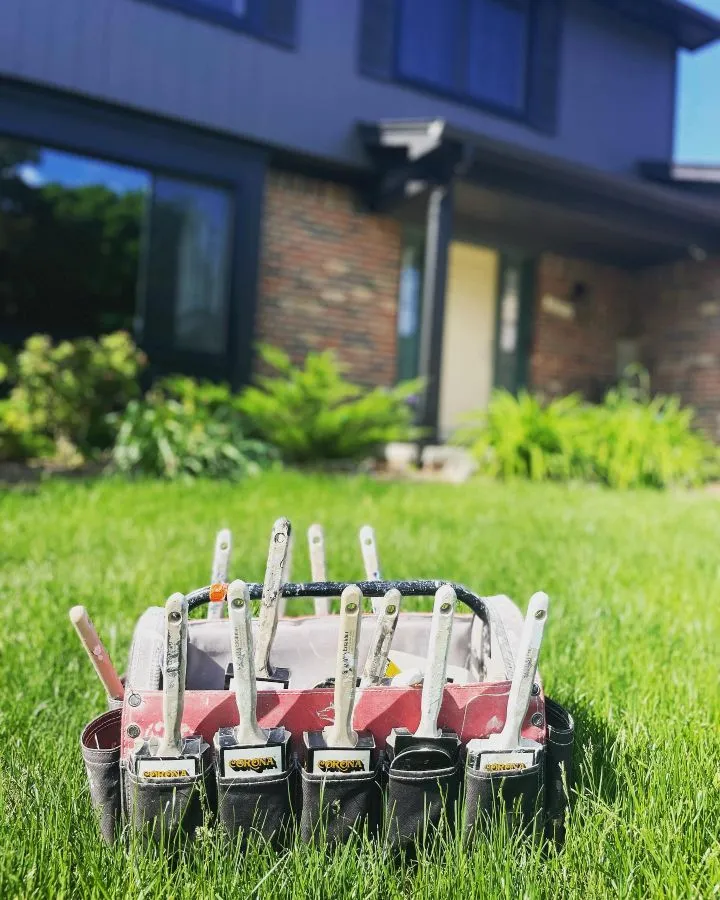 Paint brush holder in grass by house