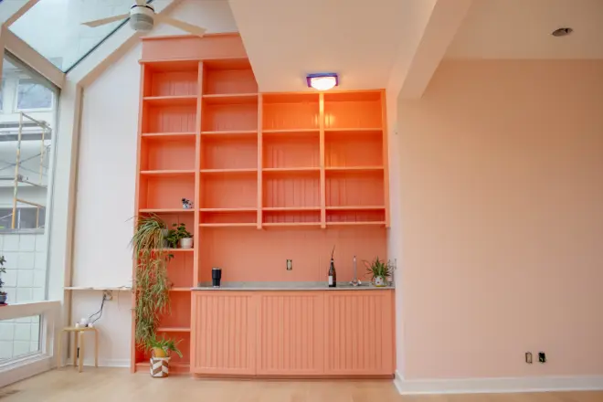 A built-in orange bookcase painted by Tribble Painting Company